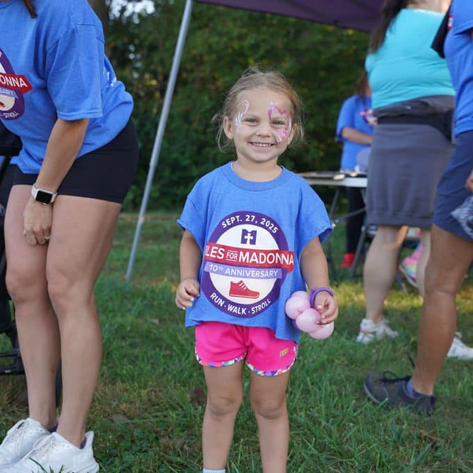 young girl with face paint smiles for the camera