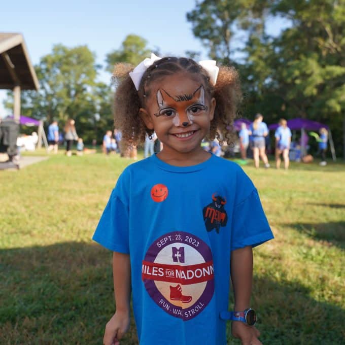 Young girl poses for picture with fox-themed face paint